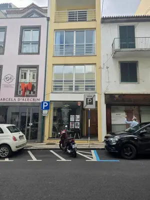 a motorcycle parked in a parking lot in front of buildings at Zen Space in Funchal