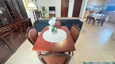 a dining room table with chairs and a couch at Sea and Sun 4 You - Villa Jardim in Santana