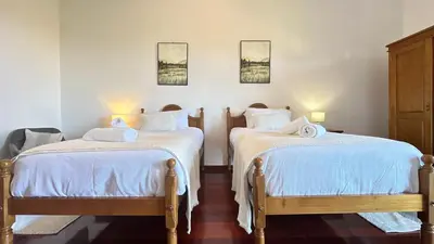two beds in a room with white sheets at Sea and Sun 4 You - Villa Jardim in Santana