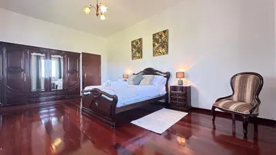 a bedroom with a bed and a chair at Sea and Sun 4 You - Villa Jardim in Santana