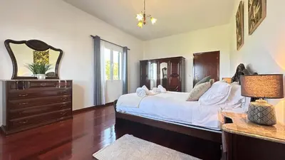 a bedroom with a bed with a dresser and a mirror at Sea and Sun 4 You - Villa Jardim in Santana