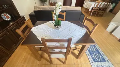 a dining room table with a vase of flowers on it at Sea and Sun 4 You - Villa Jardim in Santana