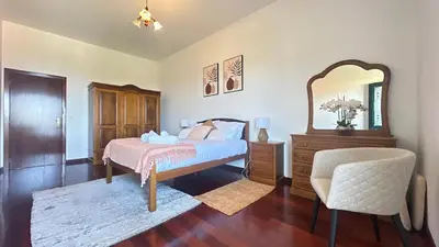 a bedroom with a bed and a mirror and a chair at Sea and Sun 4 You - Villa Jardim in Santana