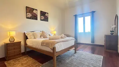 a bedroom with a bed and a dresser and a window at Sea and Sun 4 You - Villa Jardim in Santana