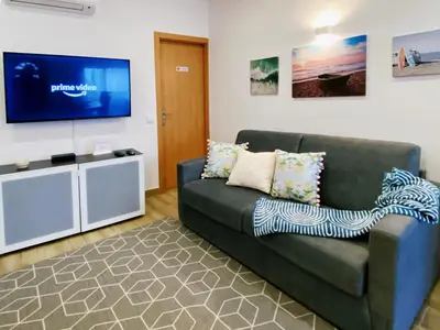 a living room with a couch and a flat screen tv at VilaMar in Salema