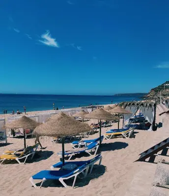 a group of chairs and umbrellas on a beach at VilaMar in Salema