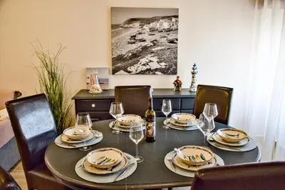 a table with plates and wine glasses on it at VilaMar in Salema