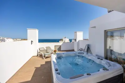 a hot tub on the balcony of a house at Burgau Beach Apartment in Burgau