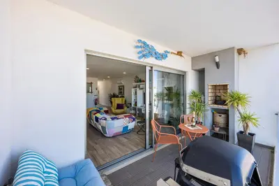 a living room with a blue couch and a bedroom at Burgau Beach Apartment in Burgau
