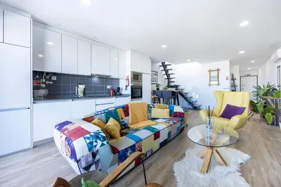 a living room with a couch and a kitchen at Burgau Beach Apartment in Burgau