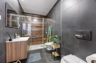a bathroom with a shower and a sink and a toilet at Burgau Beach Apartment in Burgau