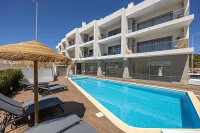 an apartment with a swimming pool and a building at Burgau Beach Apartment in Burgau