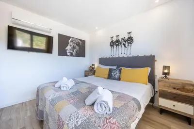 a bedroom with a bed with towels on it at Burgau Beach Apartment in Burgau