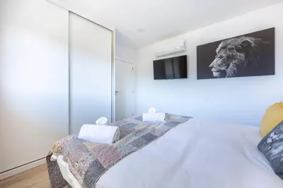 a bedroom with a bed with a lion picture on the wall at Burgau Beach Apartment in Burgau