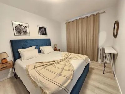 a bedroom with a large bed with a blue headboard at Vista Mar Garajau II by Rentallido in Caniço