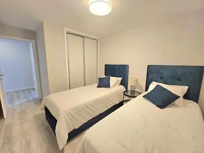 a bedroom with two beds with blue headboards at Vista Mar Garajau II by Rentallido in Caniço