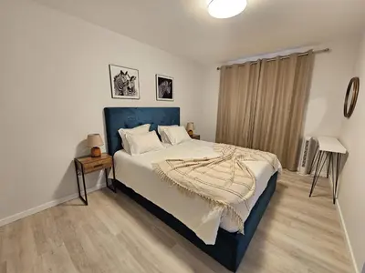 a bedroom with a large bed with a blue headboard at Vista Mar Garajau II by Rentallido in Caniço