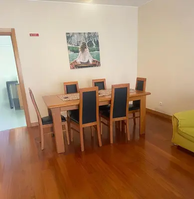 a dining room with a wooden table and chairs at Paraíso Altântico in Machico