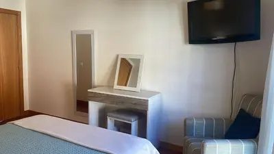 a room with a bed and a tv and a table at Paraíso Altântico in Machico