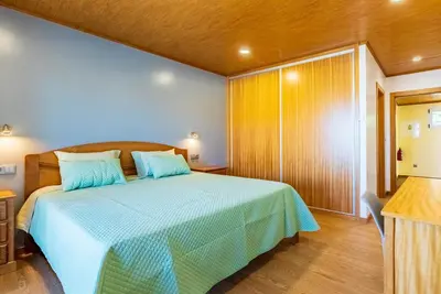 a bedroom with a bed with a blue comforter at Quinta do Til in Prazeres