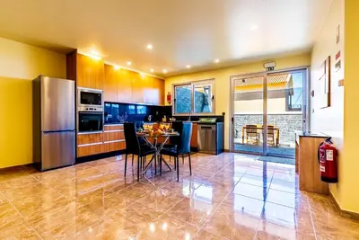 a kitchen with a table with chairs and a refrigerator at Quinta do Til in Prazeres