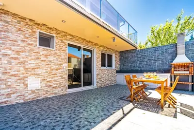 a patio with a wooden table and chairs at Quinta do Til in Prazeres