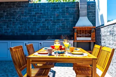 a wooden table with food and drinks on a patio at Quinta do Til in Prazeres