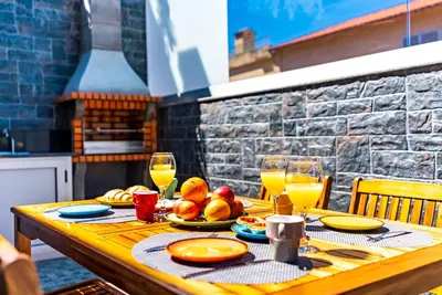 a wooden table with food and glasses of orange juice at Quinta do Til in Prazeres