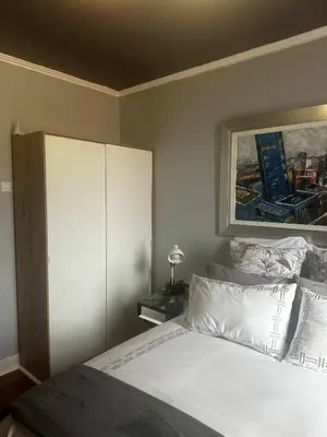a bedroom with a white bed and a painting on the wall at Miguels Seaview Corner in Ponta do Sol