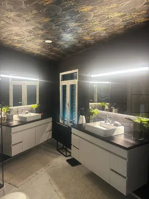 a bathroom with two sinks and two mirrors at Miguels Seaview Corner in Ponta do Sol