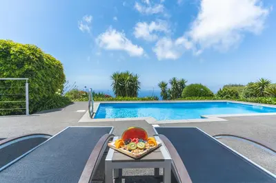 a bowl of fruit on a table next to a swimming pool at Cape View Villa by Atlantic Holiday in Ponta do Pargo
