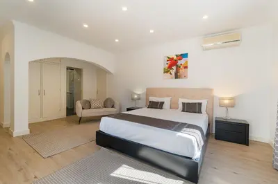 a bedroom with a large bed and a chair at Casa Tambeim in Montinhos da Luz