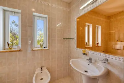 a bathroom with a sink and a mirror and a urinal at Casa Tambeim in Montinhos da Luz