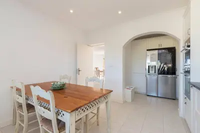 a kitchen and dining room with a wooden table and chairs at Casa Tambeim in Montinhos da Luz