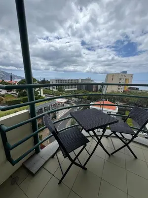 a balcony with chairs and a view of a city at Infante Santo Holidays in Funchal