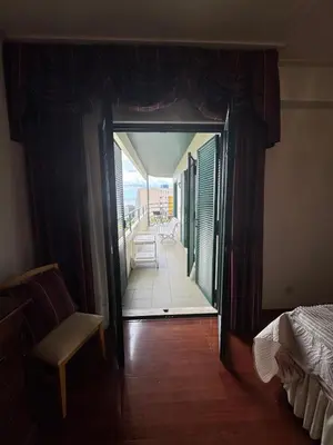 a bedroom with a door leading to a balcony at Infante Santo Holidays in Funchal
