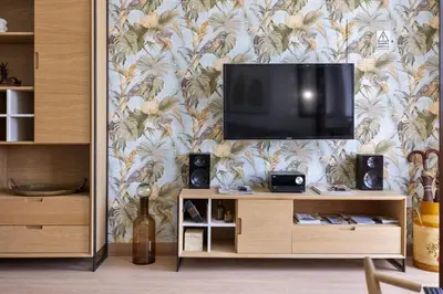 a living room with a television on a wall at Casa das Rosas - By Wehost in Santa Cruz