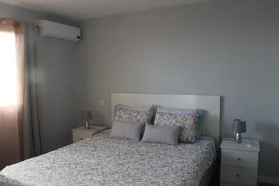 a bedroom with a bed with two night stands and two lamps at Nature Apartment 2 with Pool in Arco da Calheta