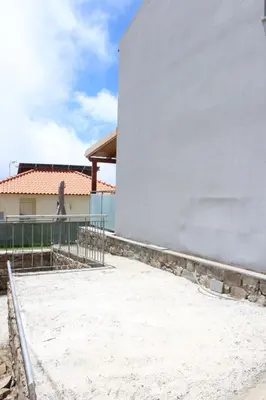 a white building with a fence next to it at Nature Apartment 2 with Pool in Arco da Calheta