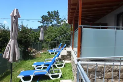 a row of blue chairs and a white screen at Nature Apartment 2 with Pool in Arco da Calheta