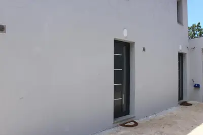 a white wall with a black door on it at Nature Apartment 2 with Pool in Arco da Calheta