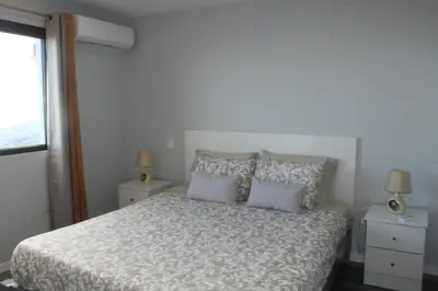 a bedroom with a bed with two night stands and two lamps at Nature Apartment 1 with Pool in Arco da Calheta
