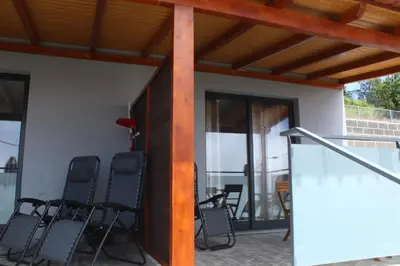 a group of chairs sitting on a patio at Nature Apartment 1 with Pool in Arco da Calheta