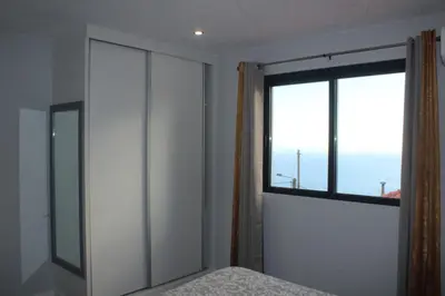 a bedroom with a window and a bed with a bedspread at Nature Apartment 1 with Pool in Arco da Calheta