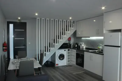 a kitchen with white cabinets and a staircase in it at Nature Apartment 1 with Pool in Arco da Calheta
