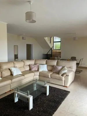 a living room with a couch and a glass coffee table at Rocha House in Calheta