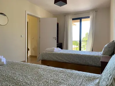 a bedroom with two beds and a window at Rocha House in Calheta