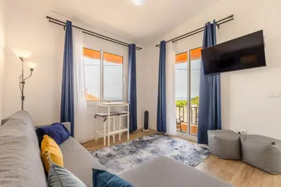 a living room with a couch and a tv at Coastal São Vicente Mountain & Sea View Hideaway with Free Parking in São Vicente