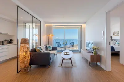 a bedroom with a bed with a blue blanket on it at Atlantic Nest Apartment by Holiday Rental Madeira in Câmara de Lobos