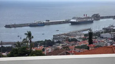 a balcony with a table and chairs and an umbrella at Santa Maria Villa in Funchal